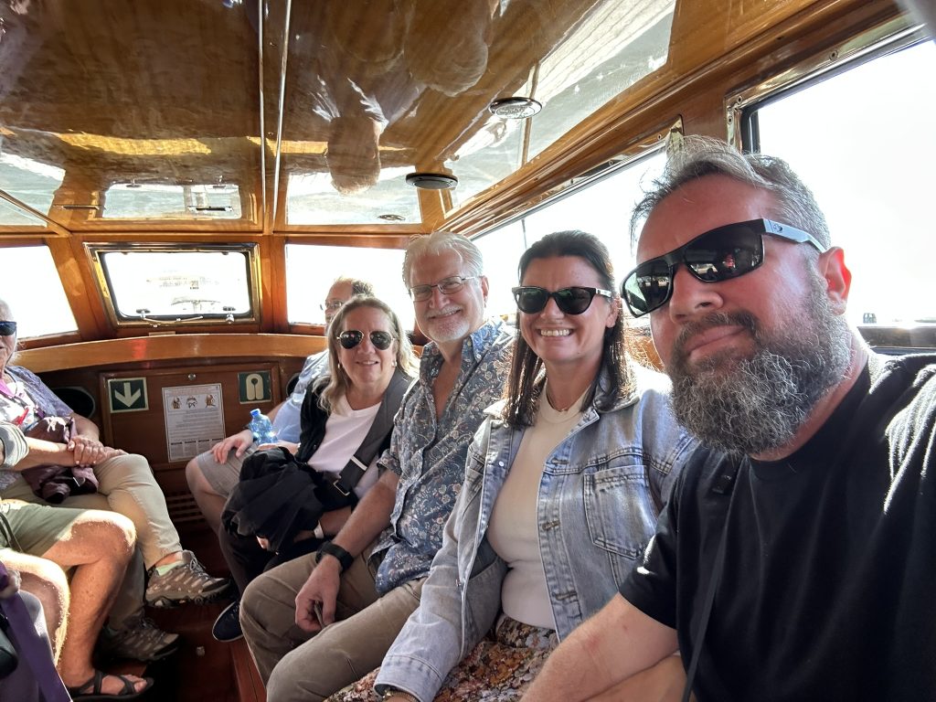 Four family members seated together on a boat during a Venice excursion