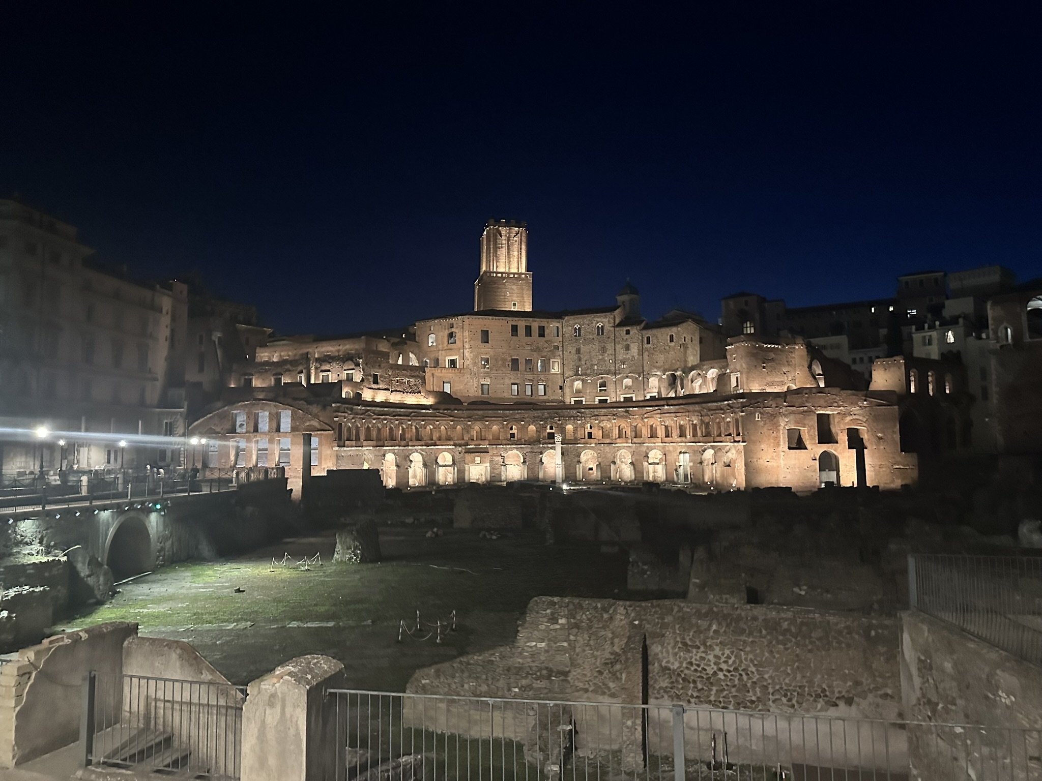 Illuminated ancient ruins and Imperial Forums area in Rome before sunrise