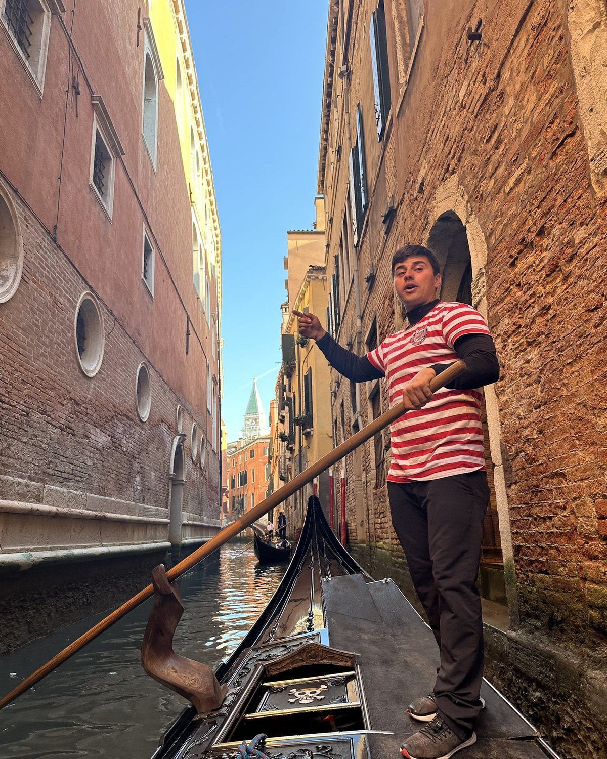 Gondolier steering through a narrow Venice canal